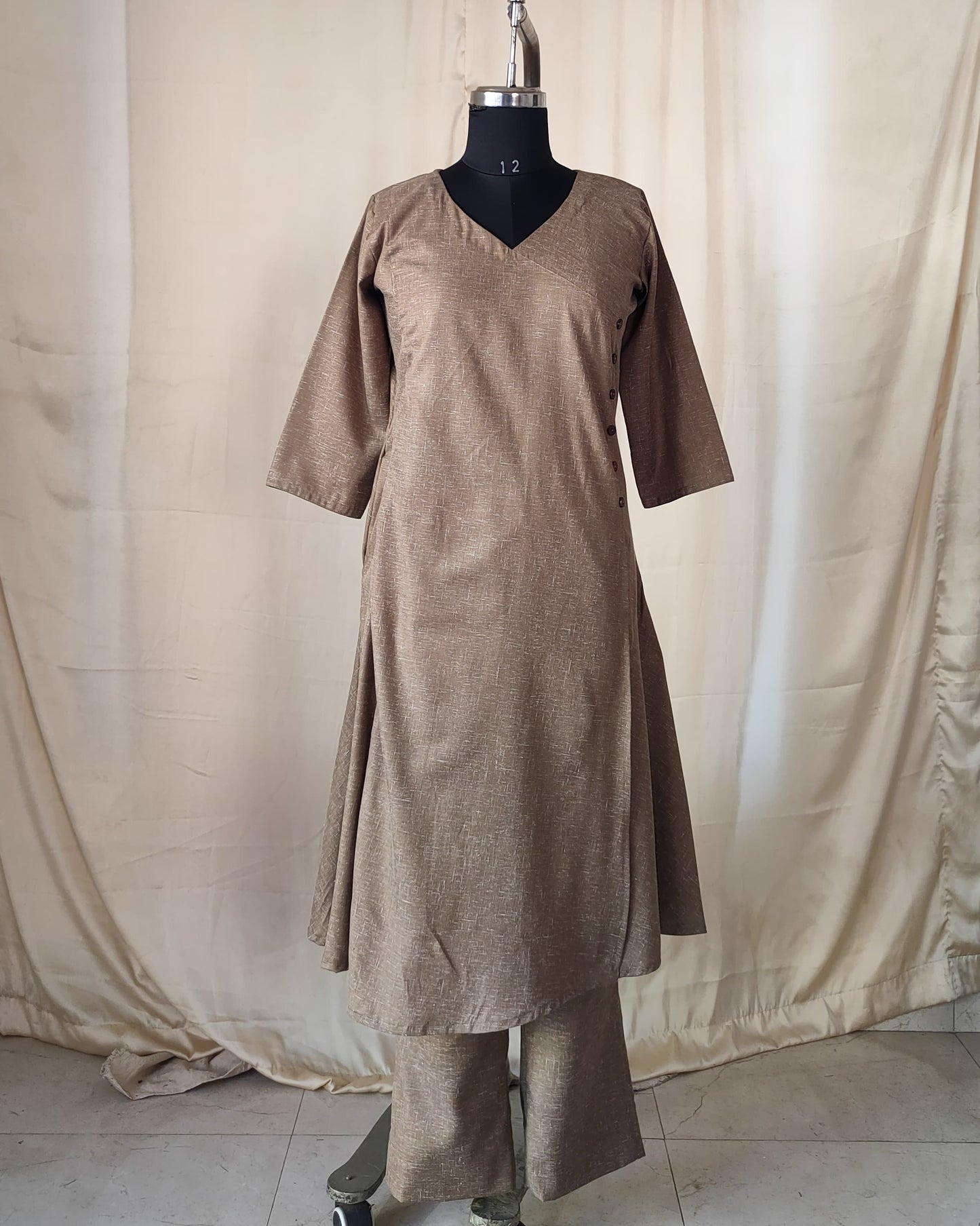 202	Beige co-ord set with overlap pattern and buttons