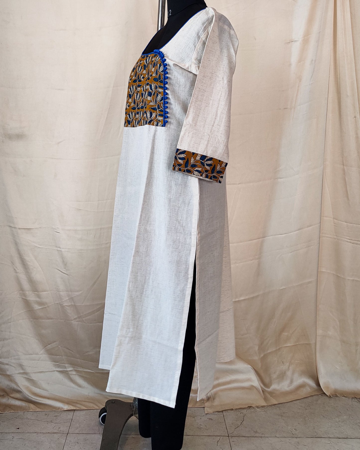 20 Cream Kurta With Blue And Mustard Yoke And Blue Potlis